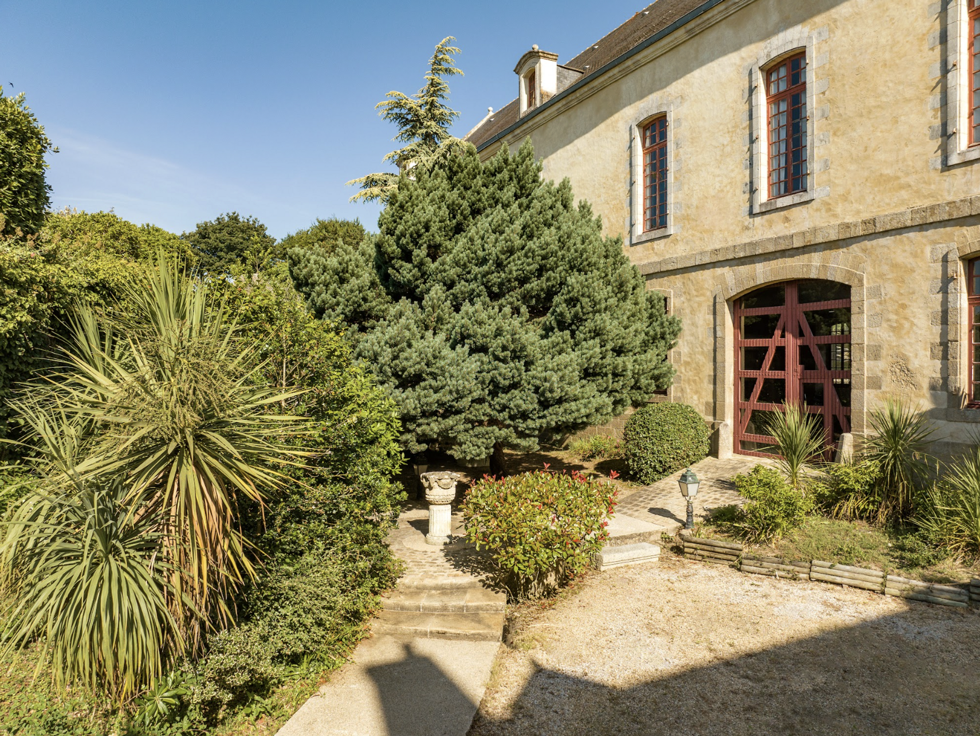 D&eacute;tail d'un b&acirc;timent historique de la Citadelle Vauban pr&eacute;sentant une architecture en pierre et une large porte cintr&eacute;e en bois