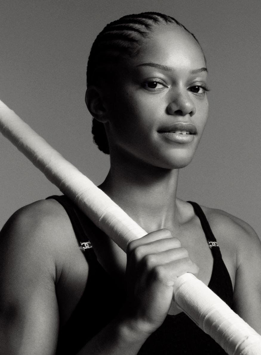 Portrait de la perchiste française Marie-Julie Bonnin, membre de la CC League par Chanel Beauté, posant avec sa perche. Elle porte une tenue de sport technique ornée du logo Chanel, symbolisant l'alliance entre performance athlétique et élégance.