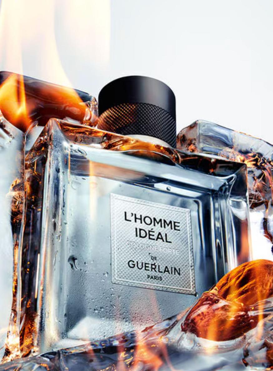 Flacon de parfum Guerlain L'Homme Idéal Cologne Forte sur un fond naturel évoquant l'agriculture biologique et la pureté de l'alcool de pois.